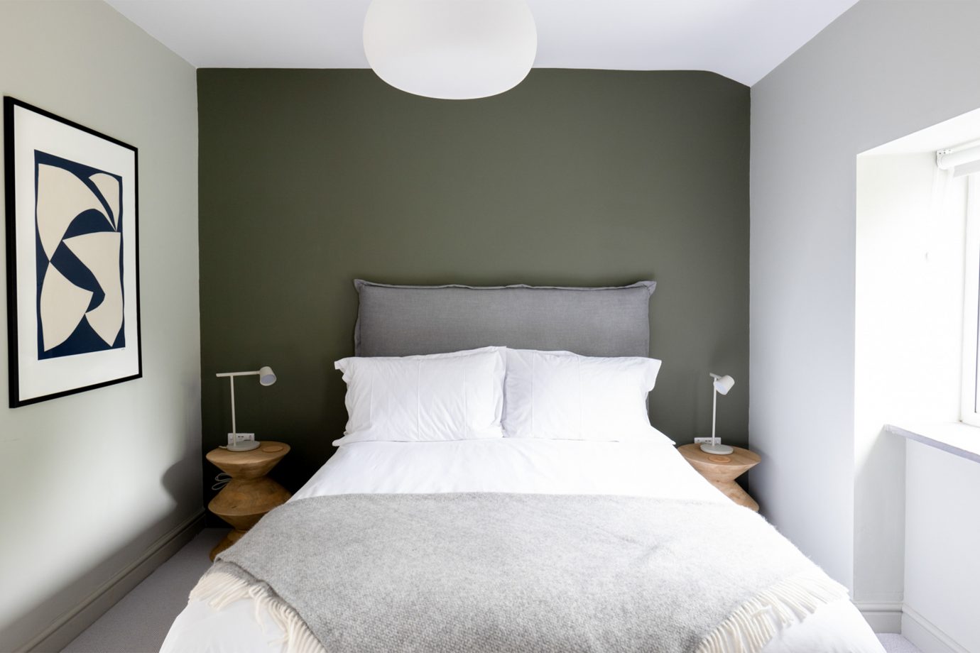 Bedroom, bed, green wall, painting, bedside table, window, natural light