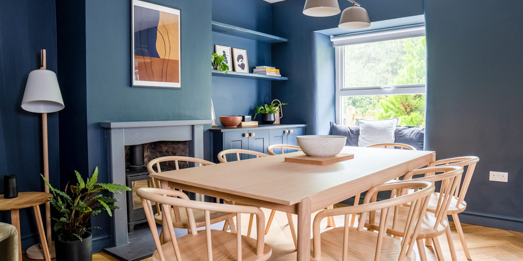 Dining table, window, blue walls, natural light, decor, plant, painting, wooden floorboard, spacious